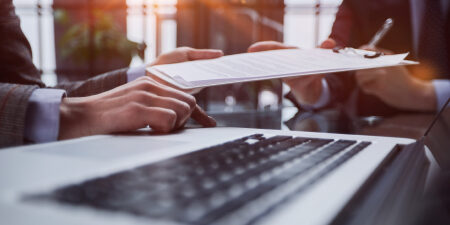 The IVA Process explained feature close up of clipboard being handed from one pair of hands to another