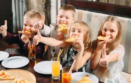 Kids eating pizza at a restaurant