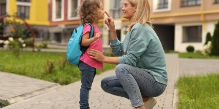 Women with her child smiling outside of a block of flats
