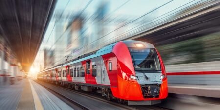Image of a red train driving fast on the tracks