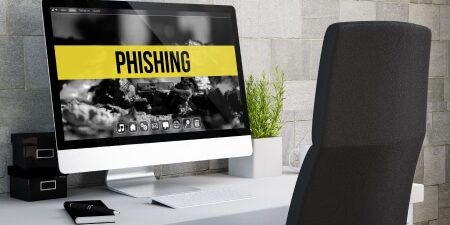 An image of an imac with the word "phishing" on the screen