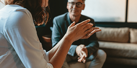 Image of a man and a woman sitting on a sofa having a chat.