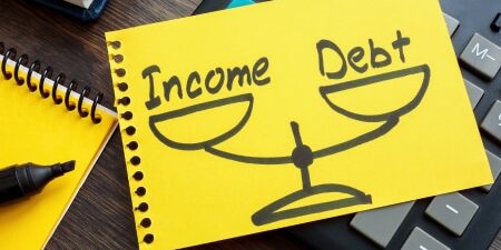 Image of a scale with income on one side and debt on the other.