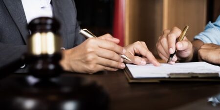 Image of two people signing a piece of paper