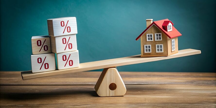 A wooden seesaw balancing house blocks and percentage blocks.