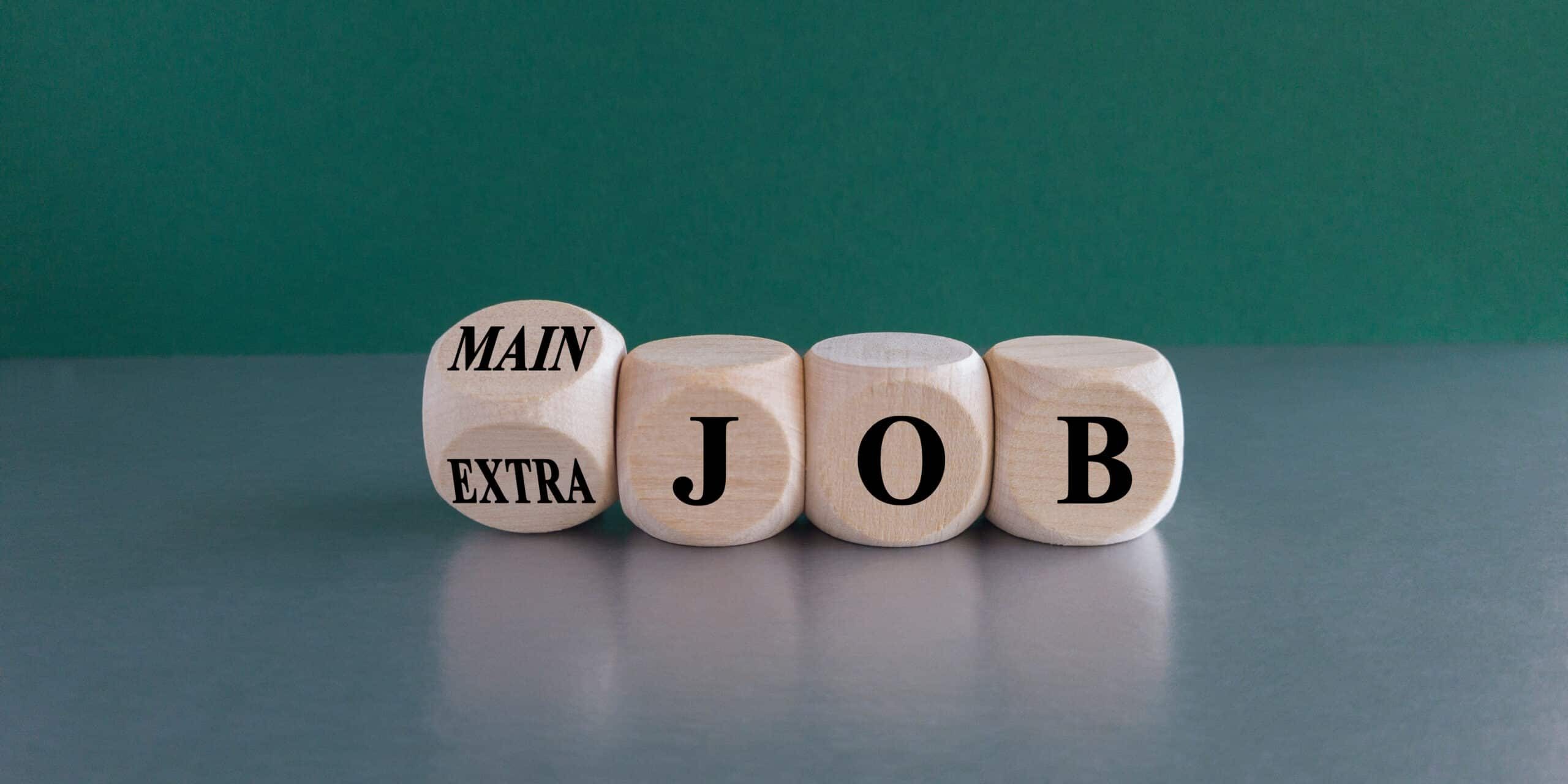 Wooden blocks displaying "MAIN JOB" or "EXTRA JOB", symbolising career choices.