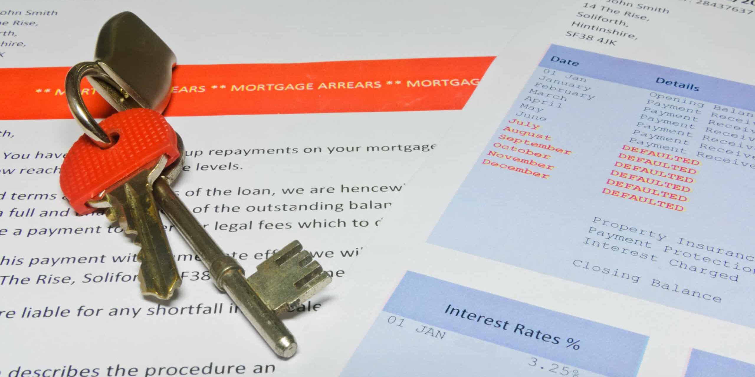 A mortgage arrears notice and mortgage statement with house keys on top.