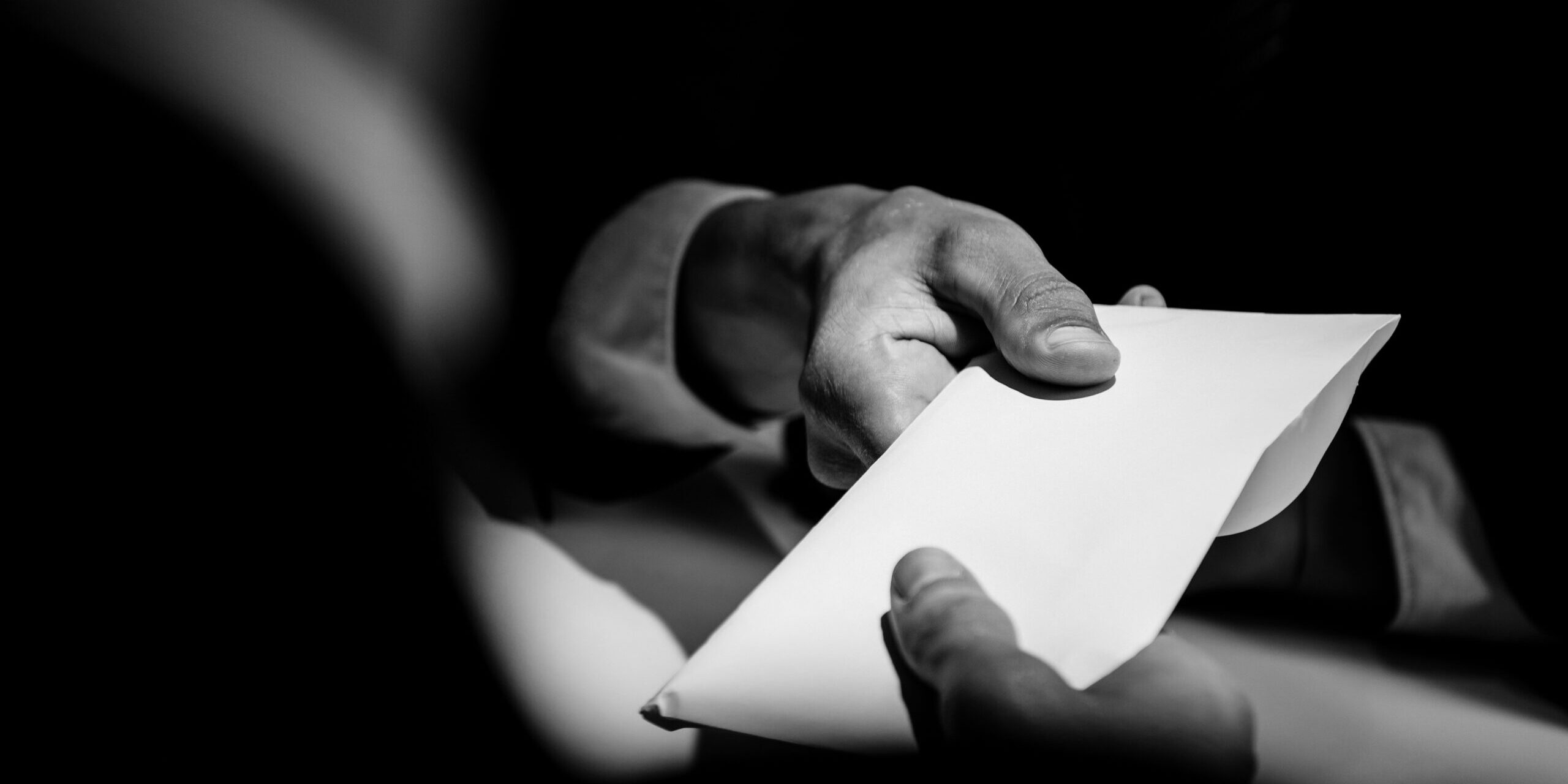 People exchanging blank envelope